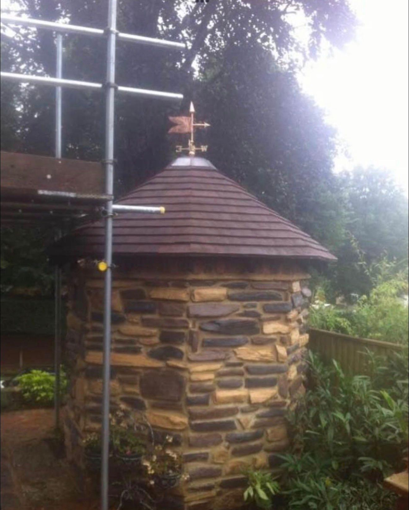 Completed plane tile log cabin with soaker ridge and lead wind chime